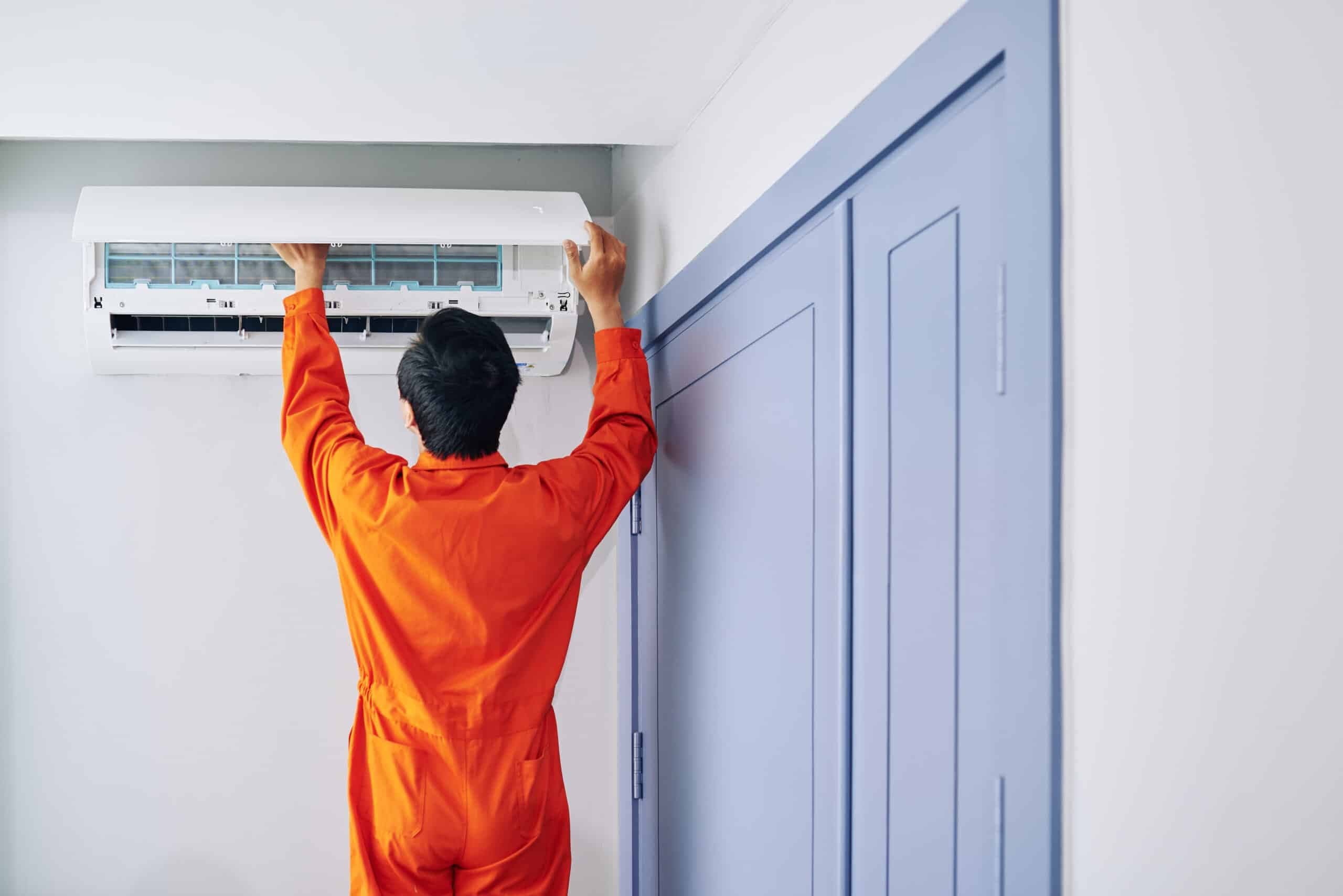 Technicien installant une unite de climatisation